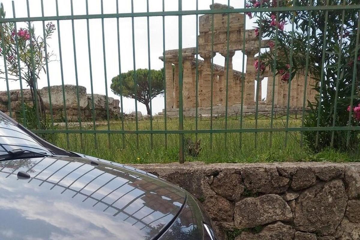 ένα αυτοκίνητο παρκαρισμένο μπροστά από έναν φράχτη με ένα κτίριο