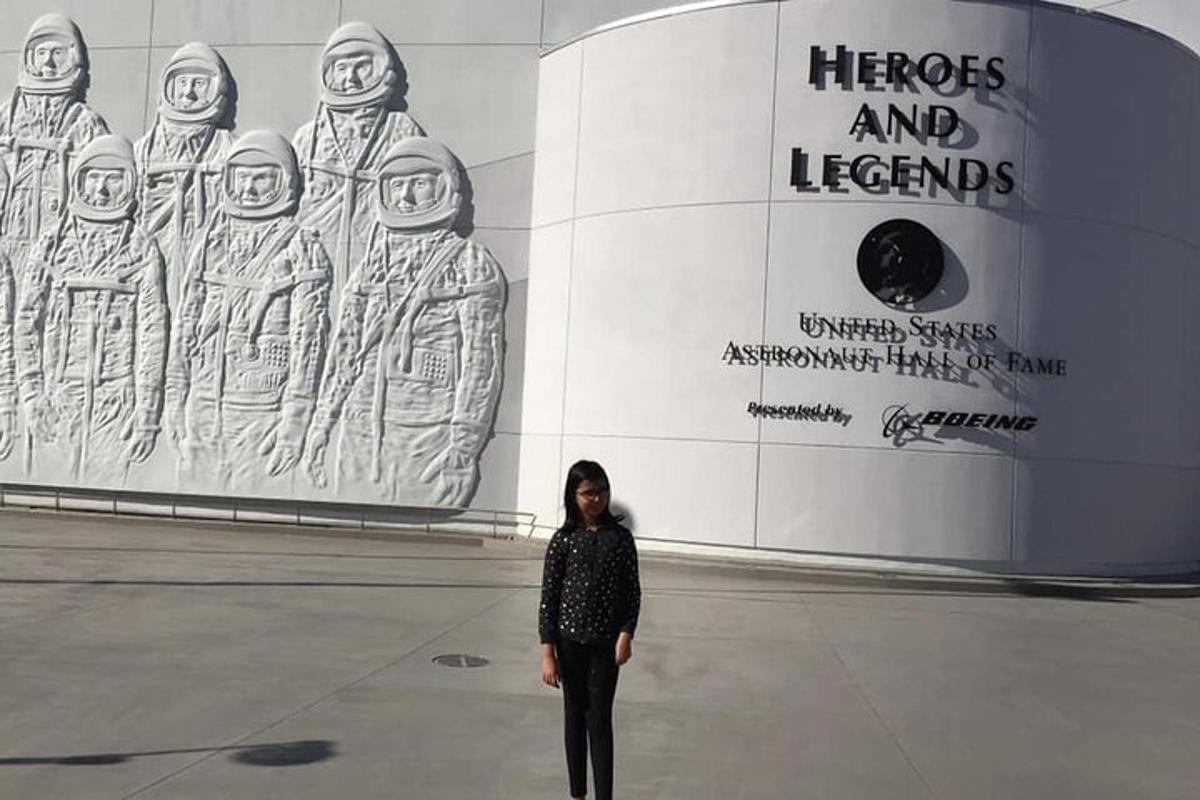 seorang wanita berdiri di hadapan bangunan dengan dinding