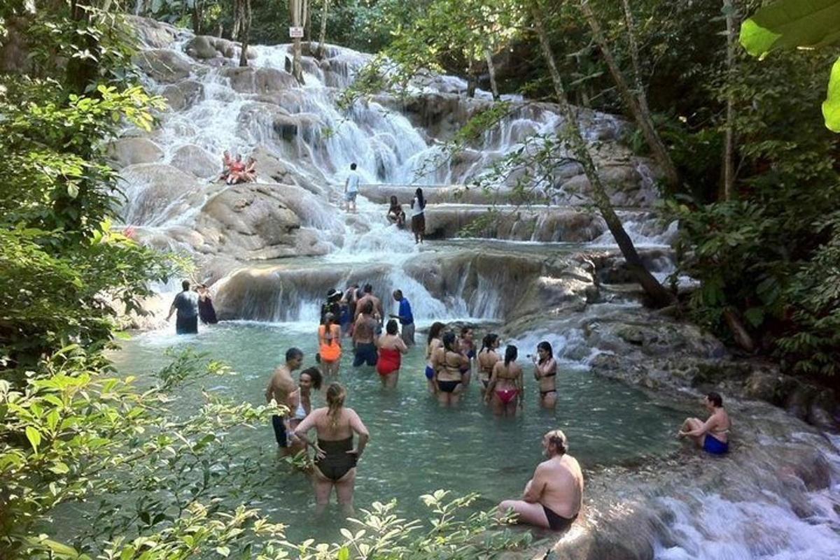 eine Gruppe von Menschen im Wasser an einem Wasserfall