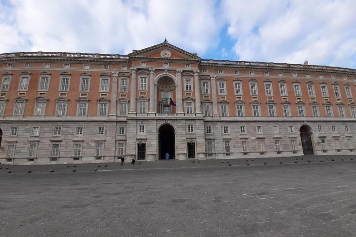 un grande edificio rosa con una bandiera davanti