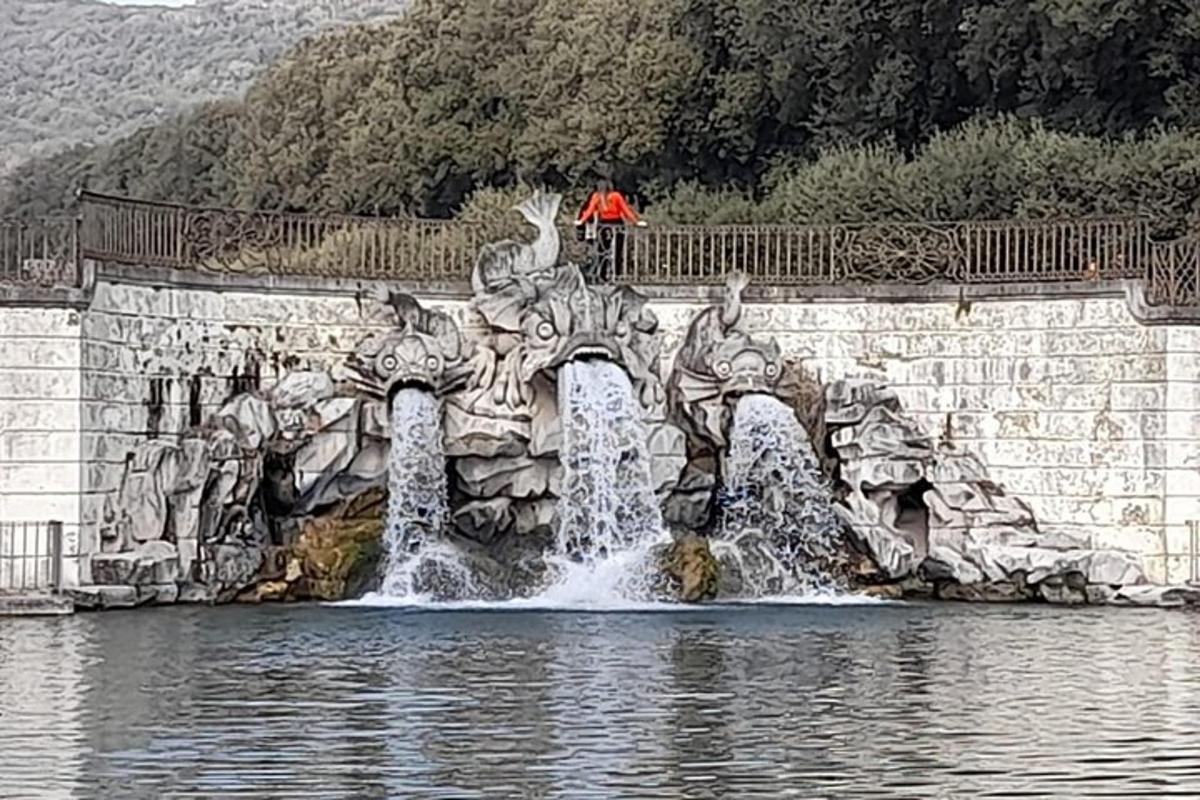 a man standing on a bridge over a water fountain