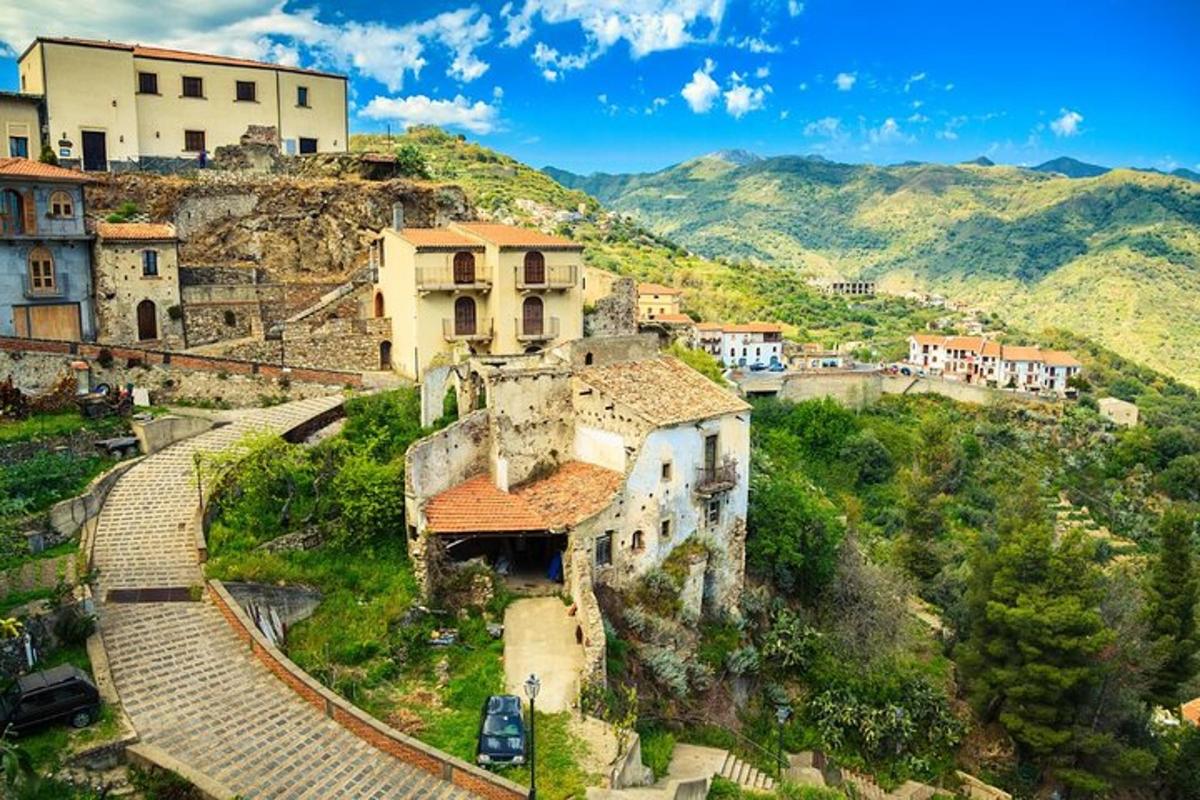 un vecchio edificio su una collina con le montagne sullo sfondo