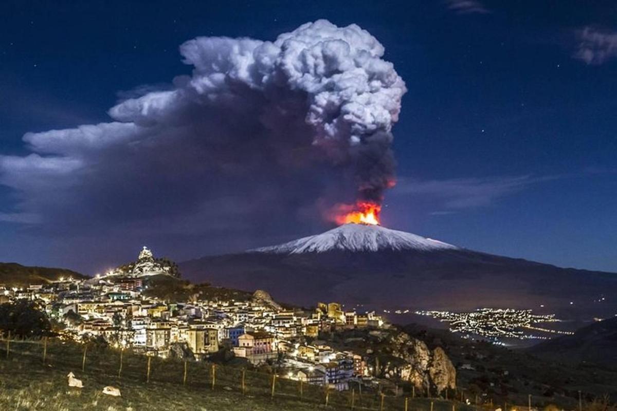 a eruption of a volcano at night with a city