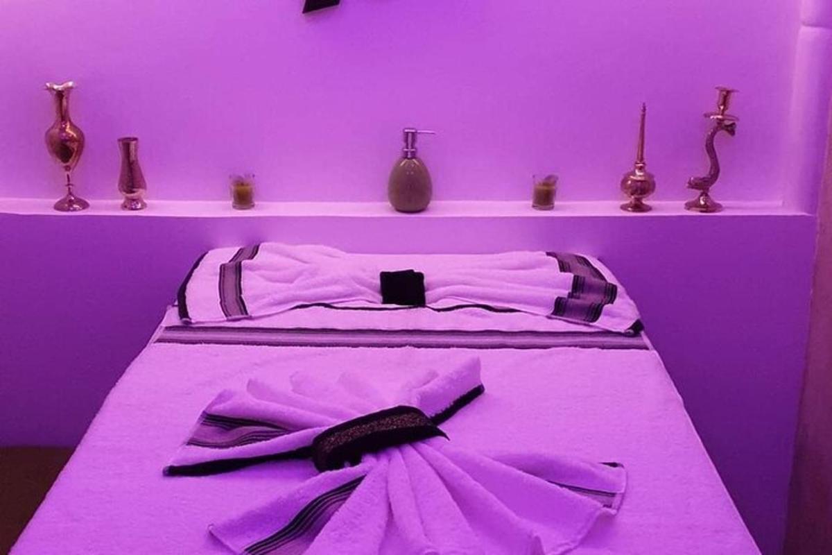 a bed in a purple room with vases