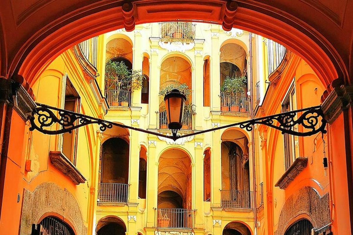 un arco di un edificio con balconi e piante
