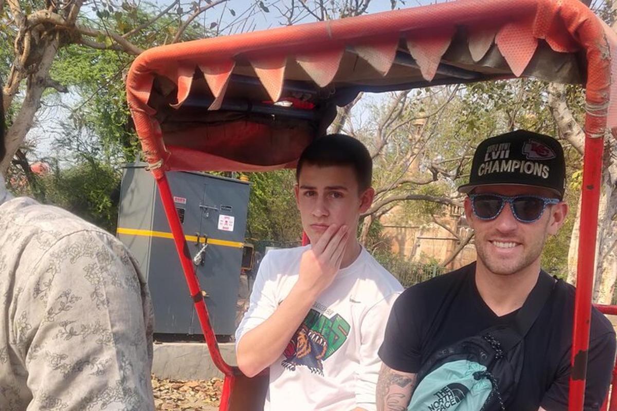 two men are sitting under a red canopy