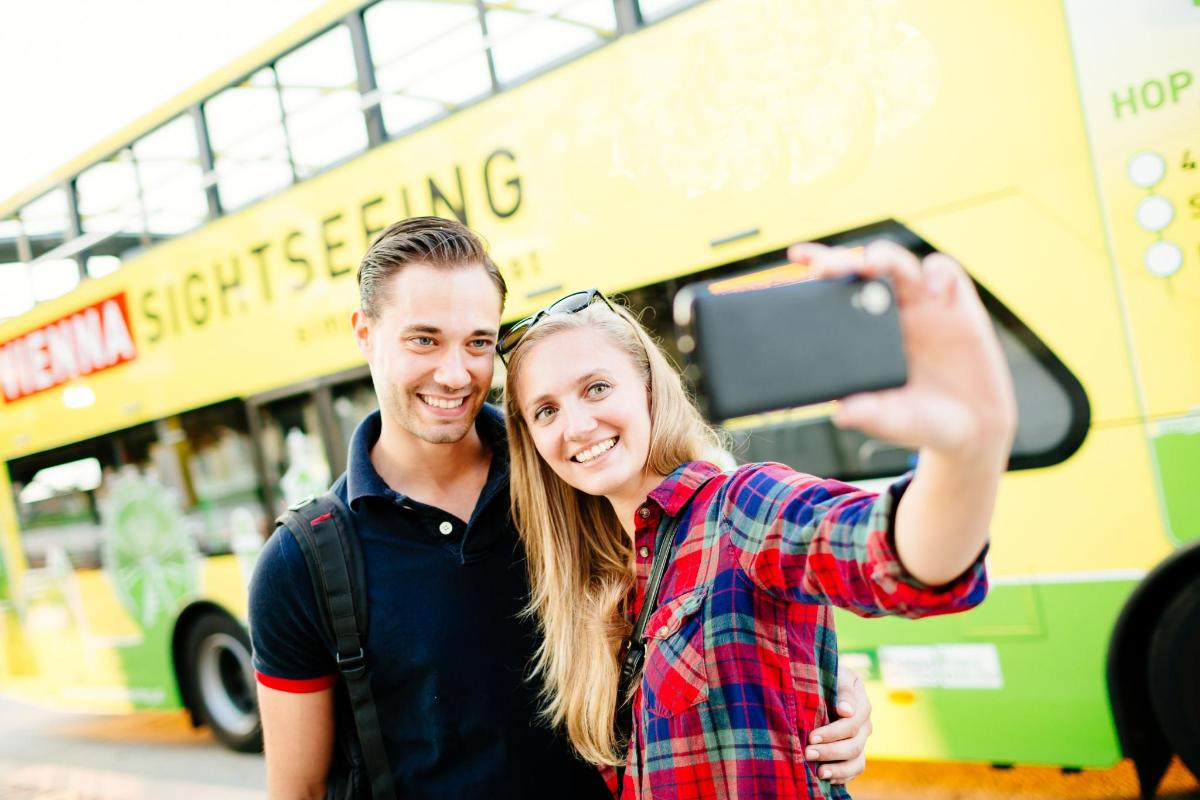 muž a žena fotí autobus