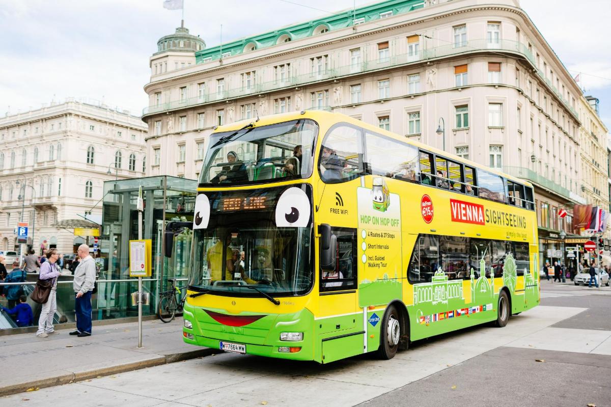 un autobus a due piani giallo e verde su una strada cittadina