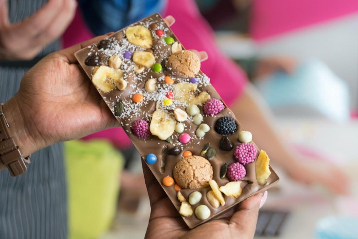 osoba držící čokoládovou tyčinku plnou sušenek a marshmallows