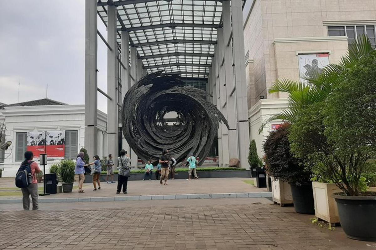 a group of people walking in a building with a sculpture