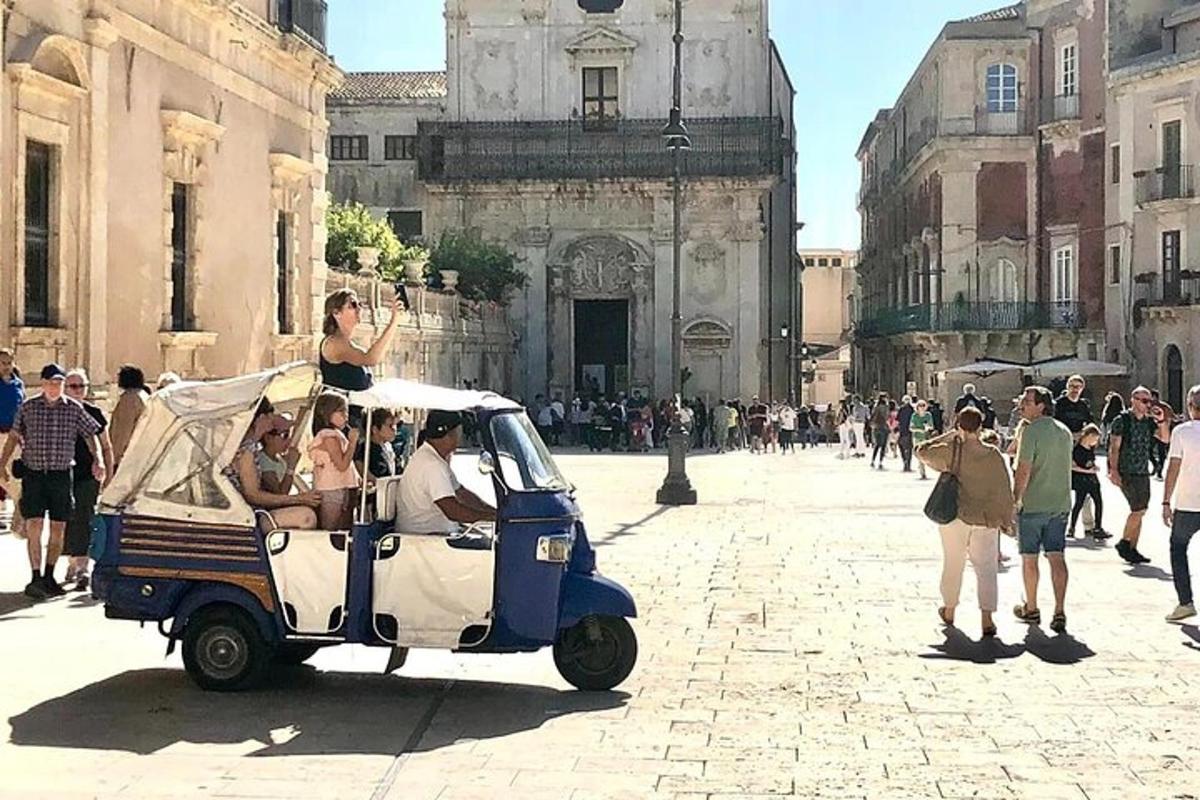 un grup de oameni care călătoresc cu o mașină de golf pe o stradă a orașului