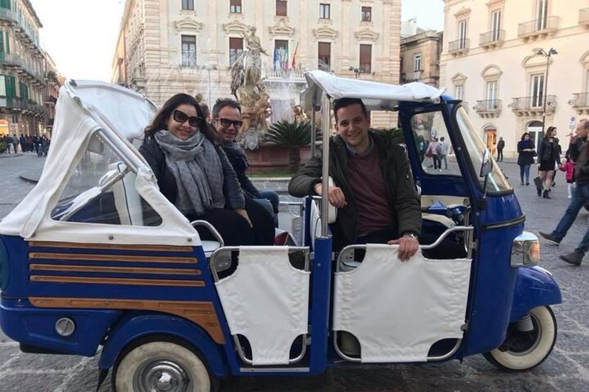 un grup de tres persones que viatgen en un carret de golf