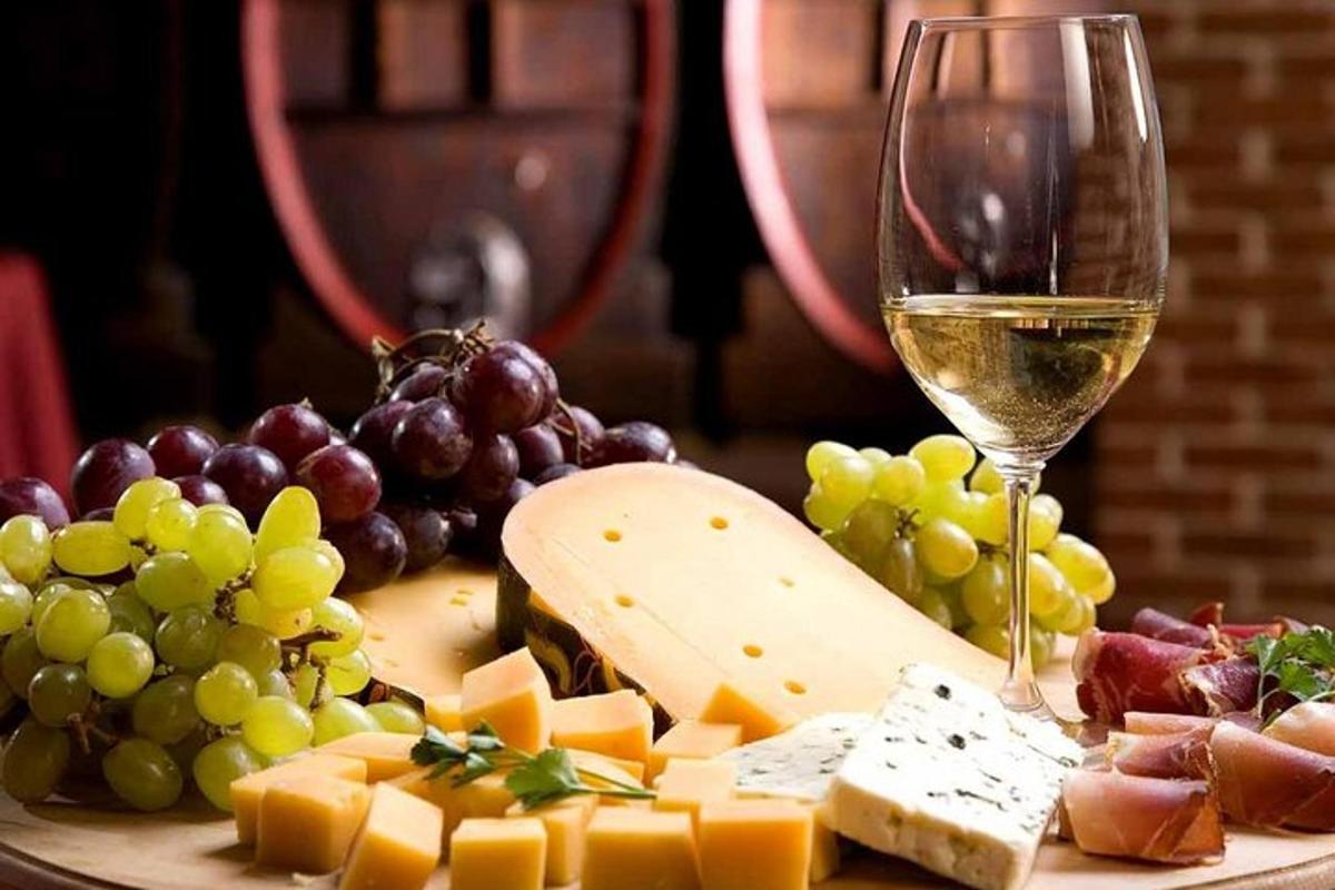 krožnik sira in grozdja ter kozarec vina