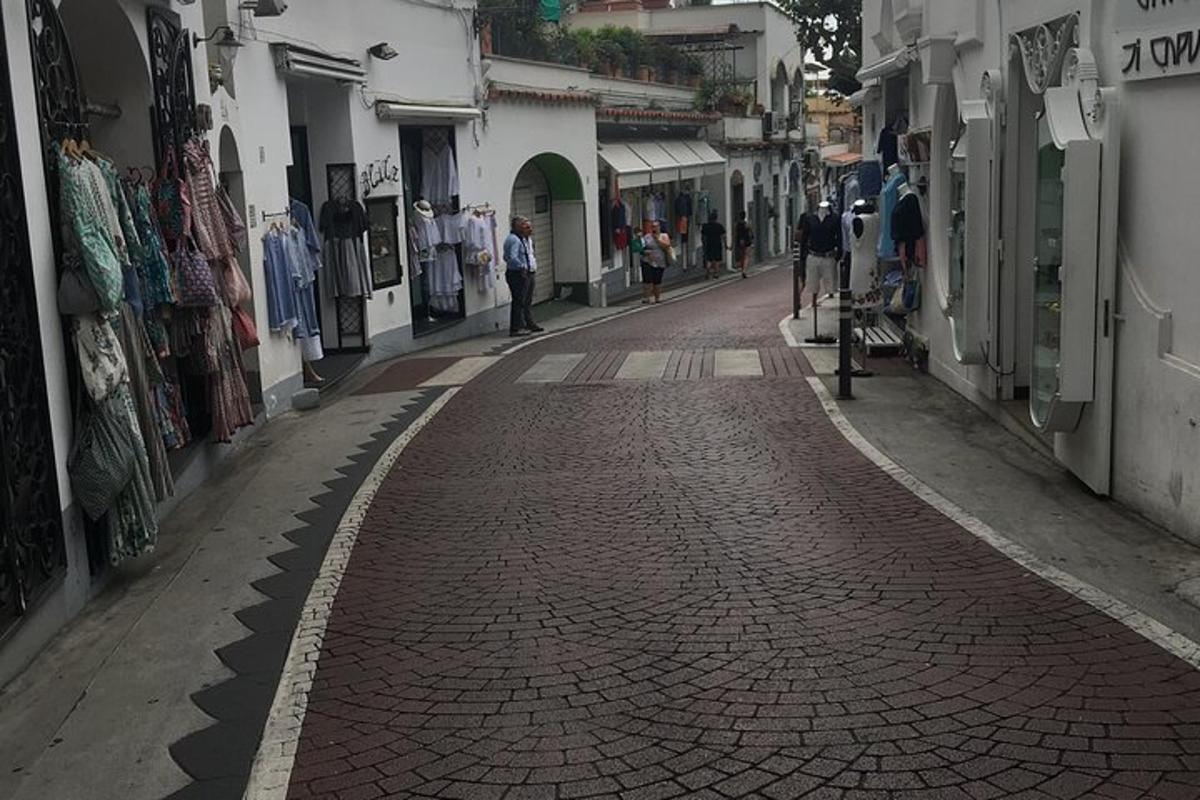 Dlážděná ulice v uličce s lidmi, kteří po ní jdou