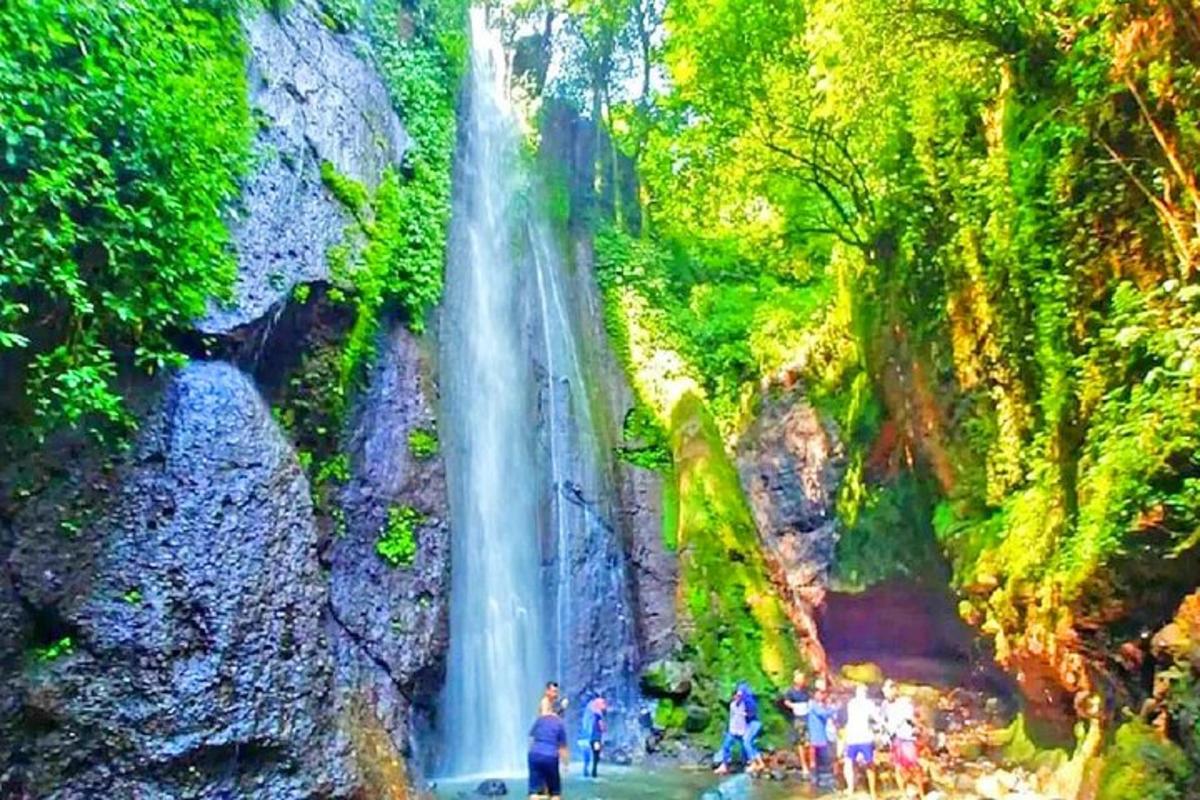 un gruppo di persone in piedi davanti a una cascata