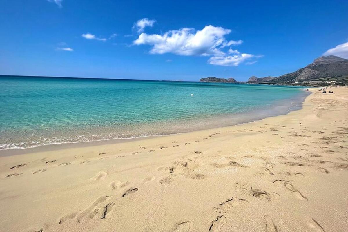 una platja de sorra amb l'oceà i l'aigua blava
