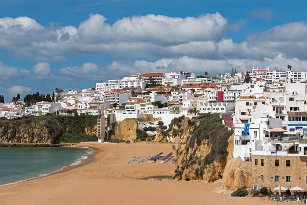 um grupo de edifícios brancos em uma colina próxima a uma praia
