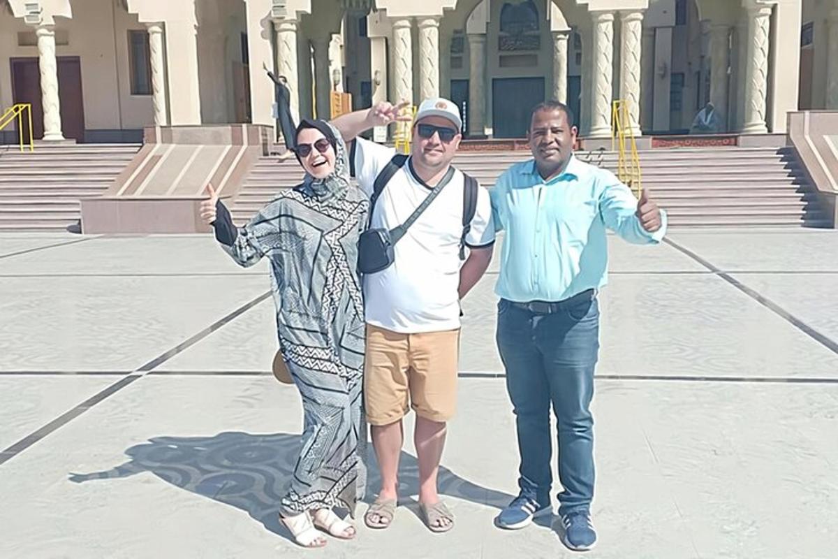 three people posing for a picture in front of a building