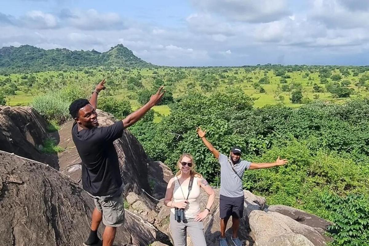 tři lidé stojící na skále se zdviženýma rukama
