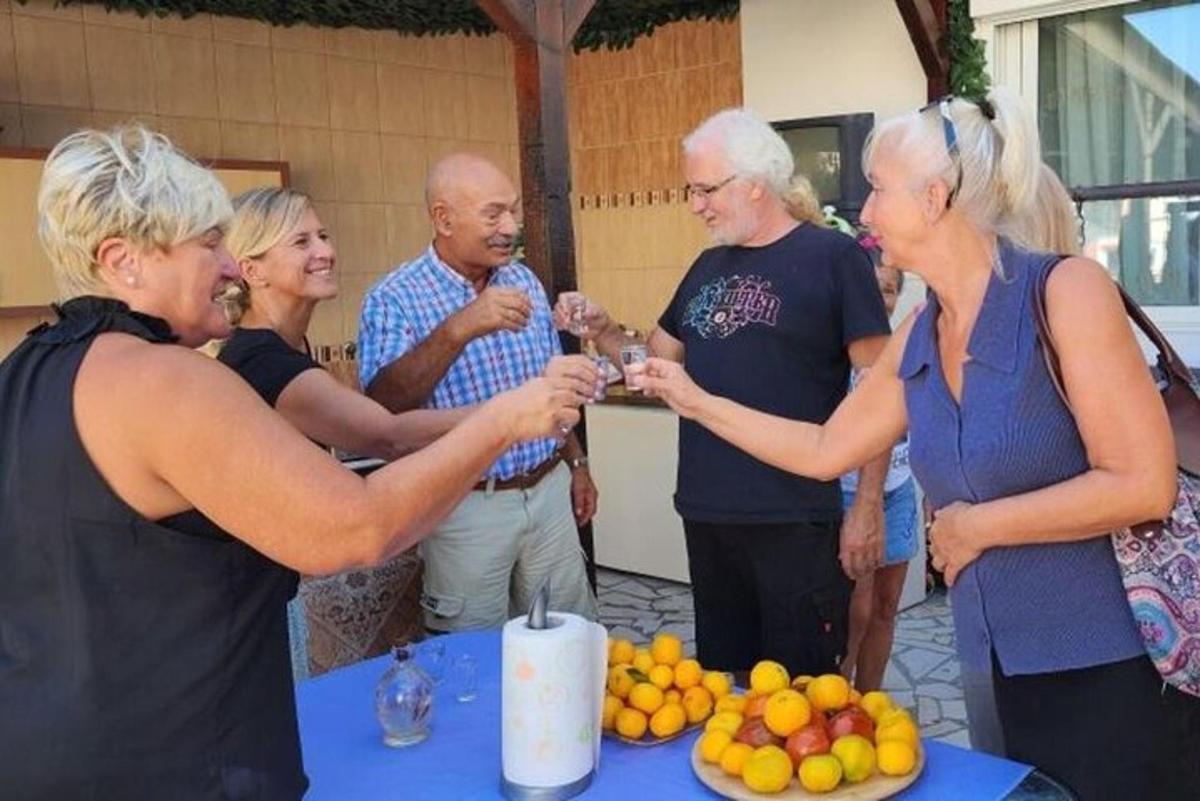 μια ομάδα ανθρώπων που στέκονται γύρω από ένα τραπέζι με φρούτα