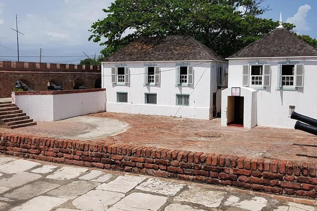 un edifici blanc amb una paret de maons al davant