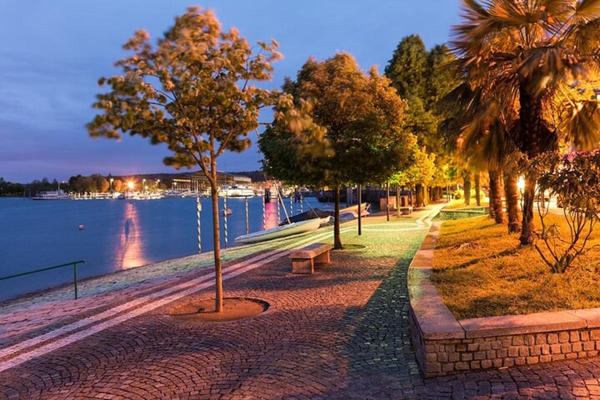 eine Straße mit Bäumen und einer Bank neben dem Wasser
