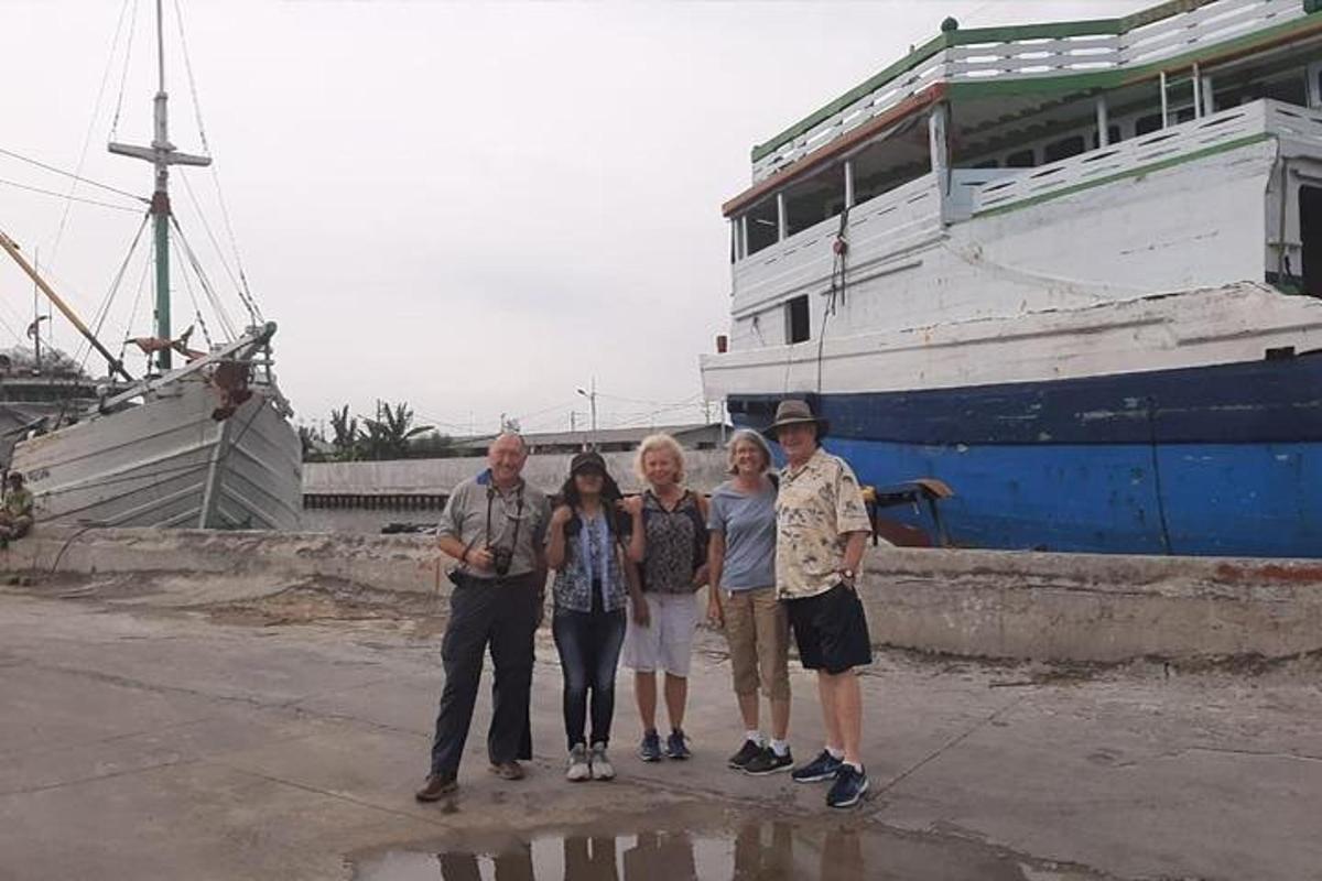 bir teknenin önünde duran bir grup insan