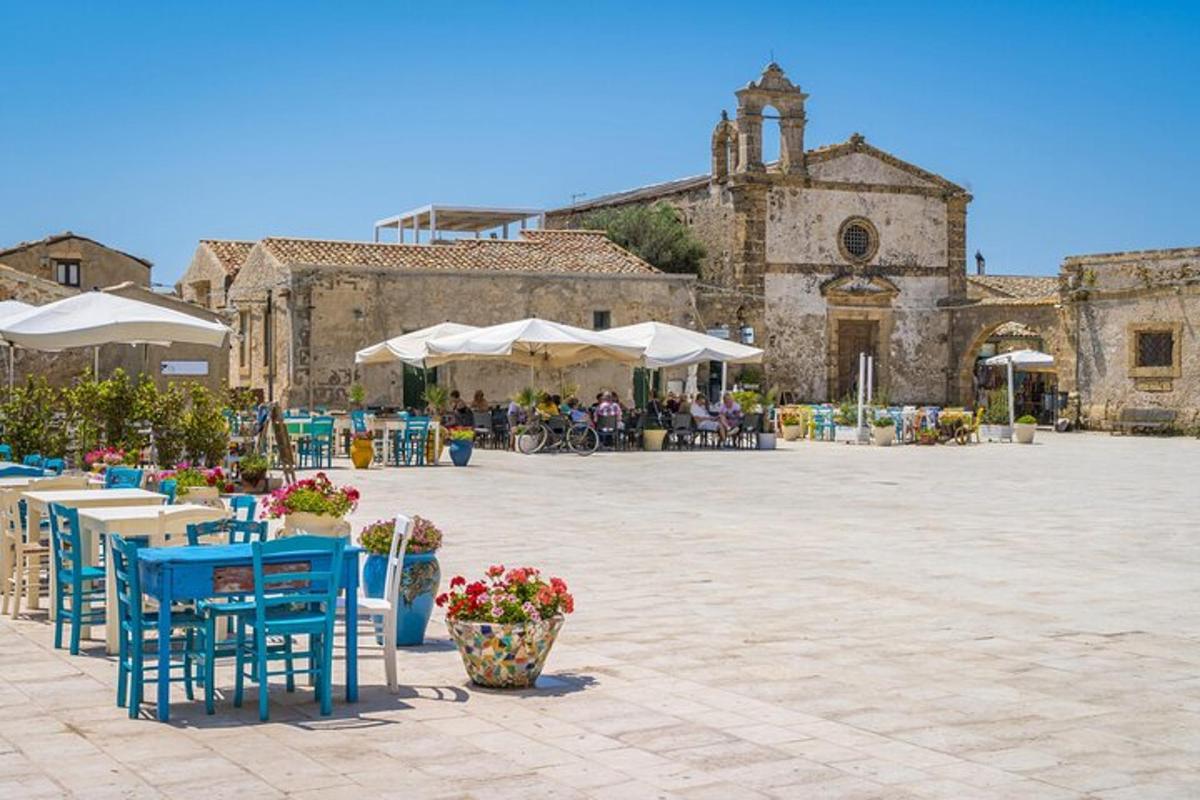Un patio con mesas y sillas frente a un edificio.