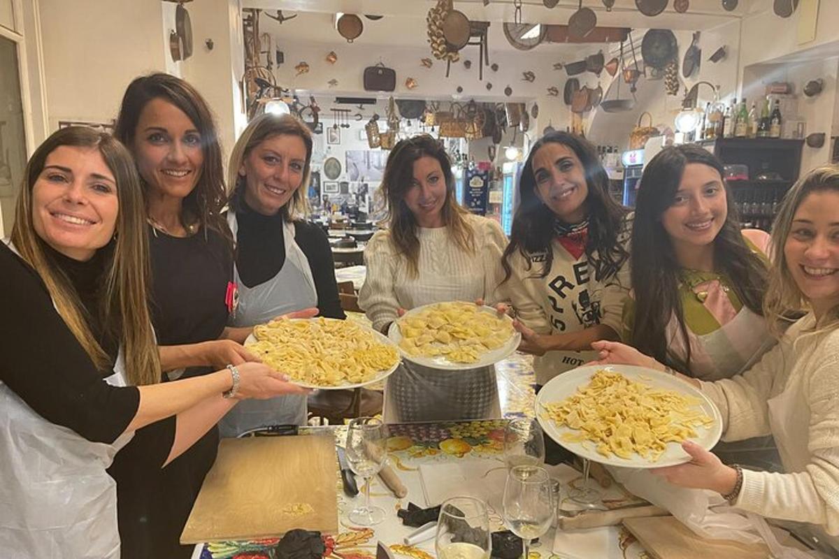 a group of women holding plates of pasta
