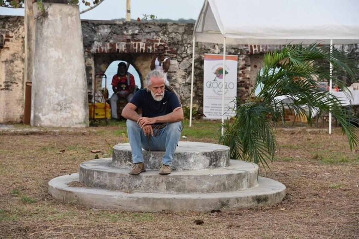 muž sedící na vrcholu kamenného monumentu