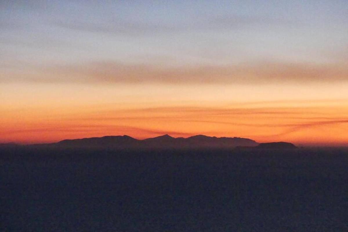 a view of a sunset with mountains in the distance