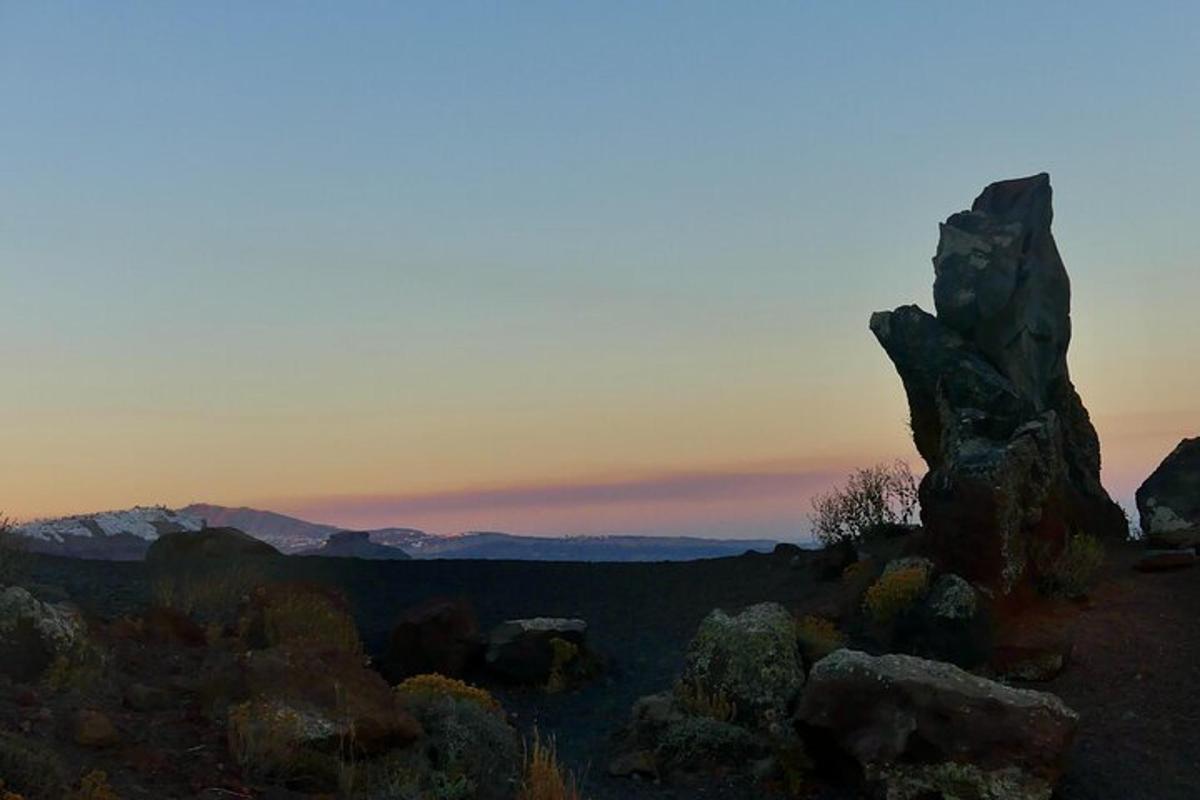 en gruppe steiner i et felt med en solnedgang