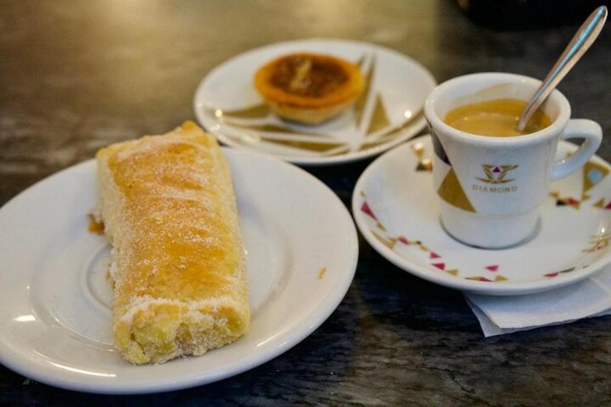 krožnik s kosom kruha in skodelico kave
