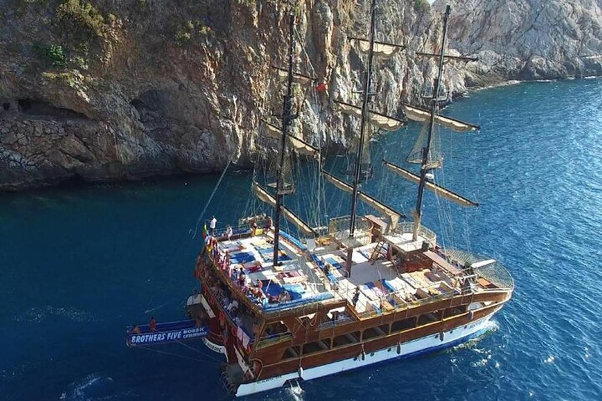 um grande barco na água próximo a um penhasco