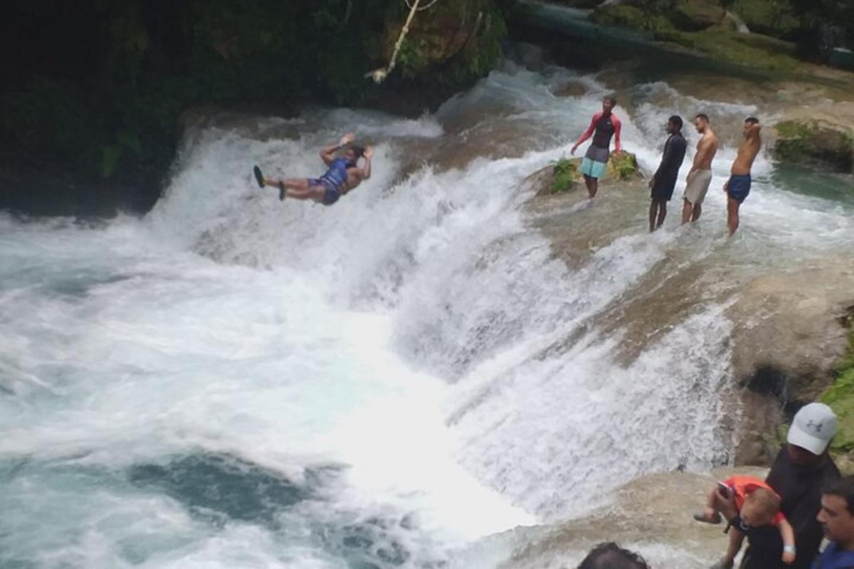 sekumpulan orang berdiri di atas air terjun