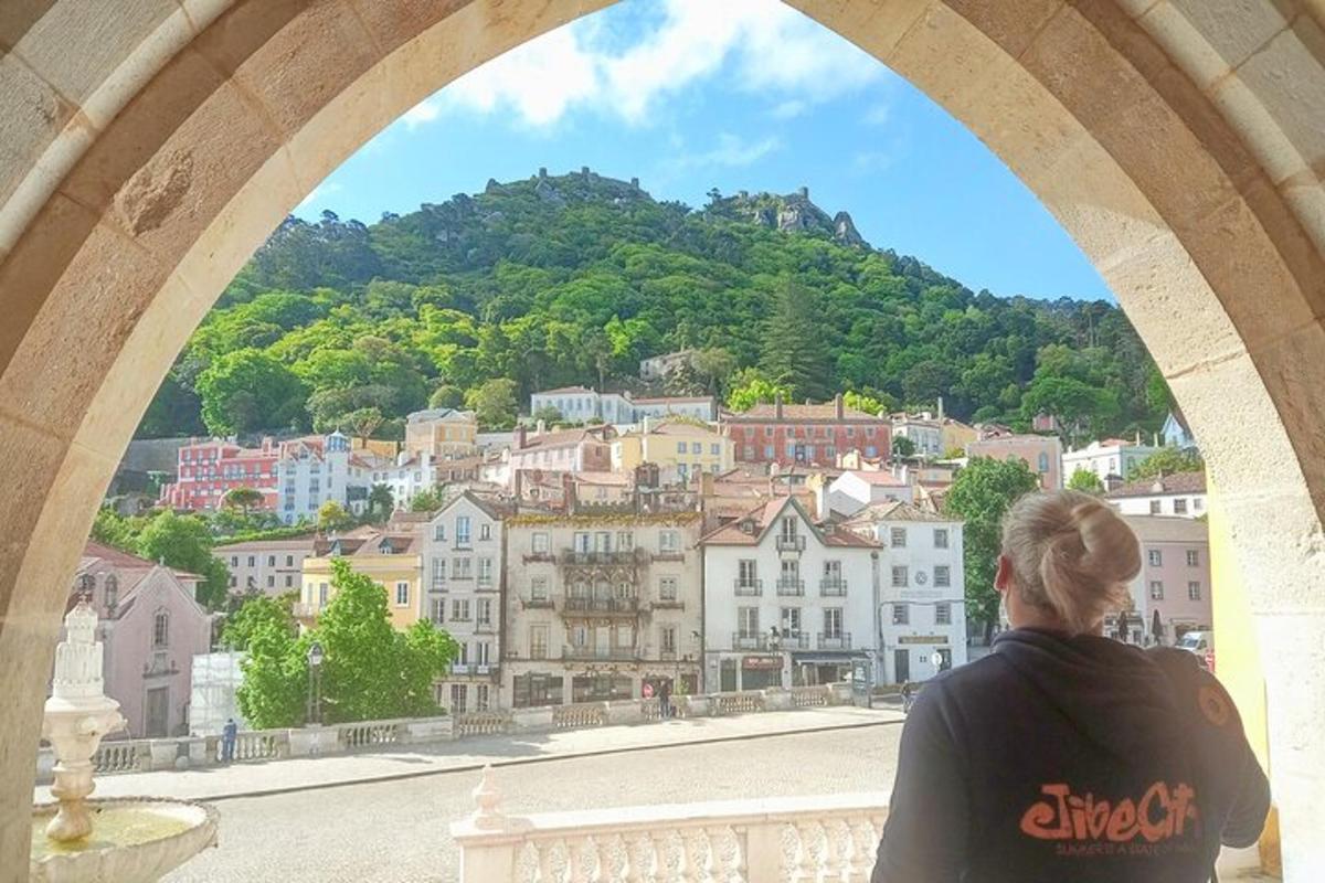 una donna che guarda fuori da un arco verso una città