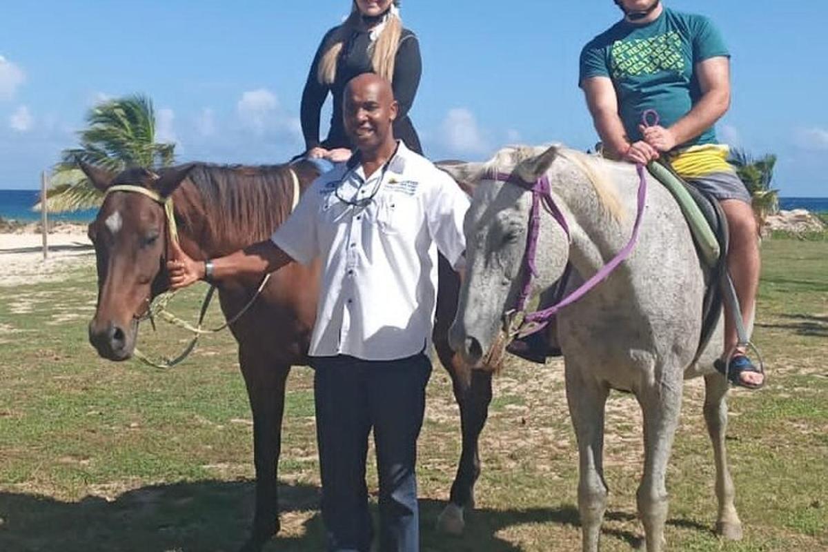 moški, ki stoji poleg dveh moških na konjih