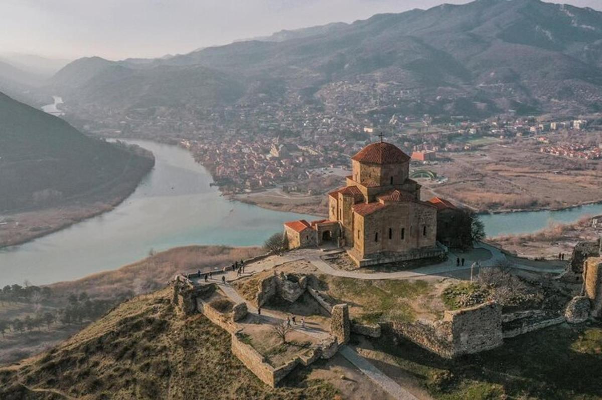 stará budova na vrcholu kopce vedle řeky