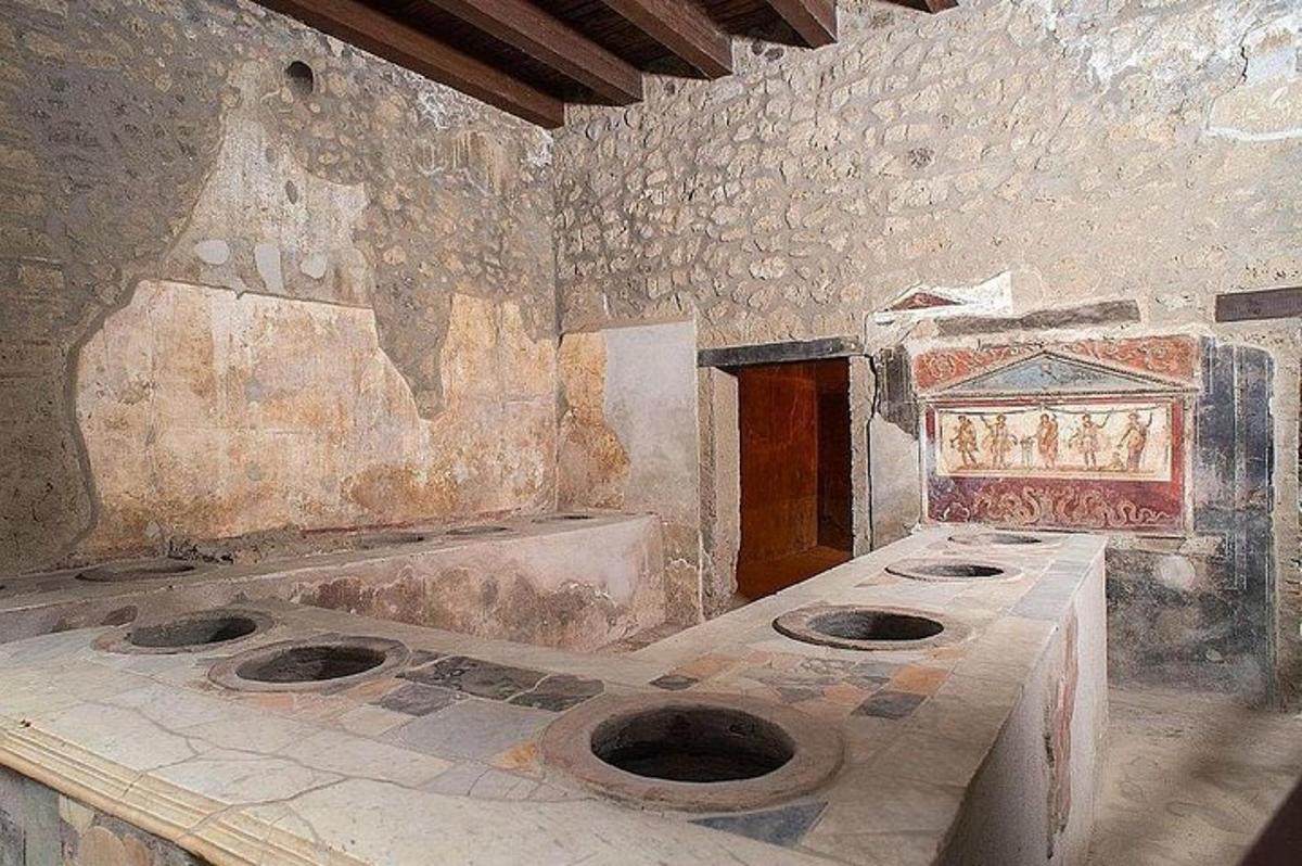 uma sala de pedra com três banheiros em um quarto