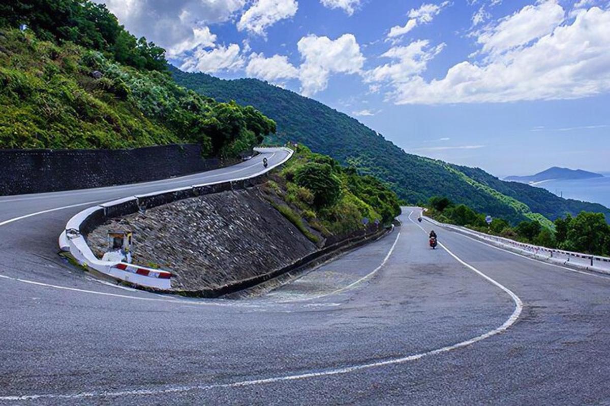 klikatá silnice s osobou jedoucí na motorce na kopci