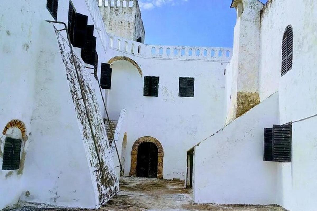 Ένα παλιό λευκό κτίριο με σκάλα και πύργο