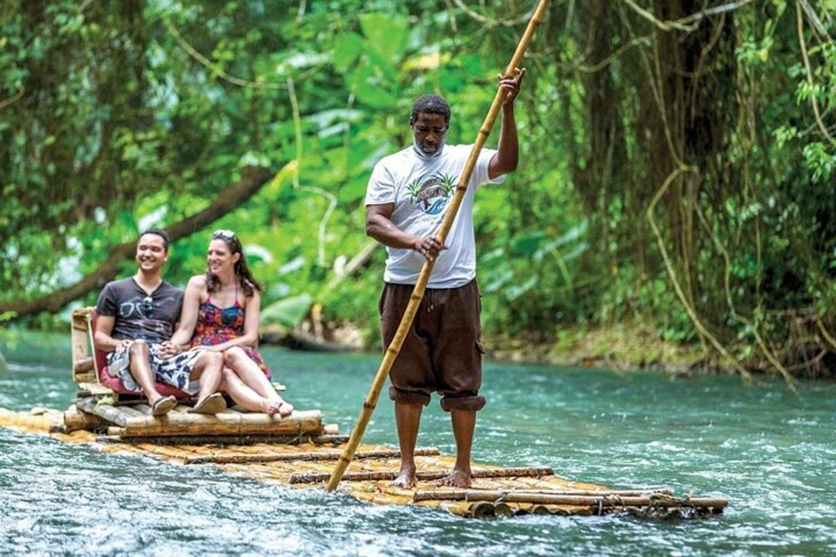Un hombre parado en una balsa de bambú en un río.