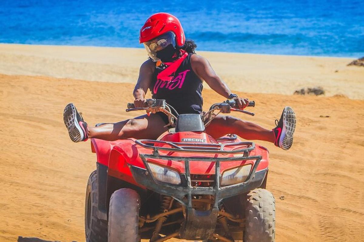 una donna seduta su un quad sulla spiaggia