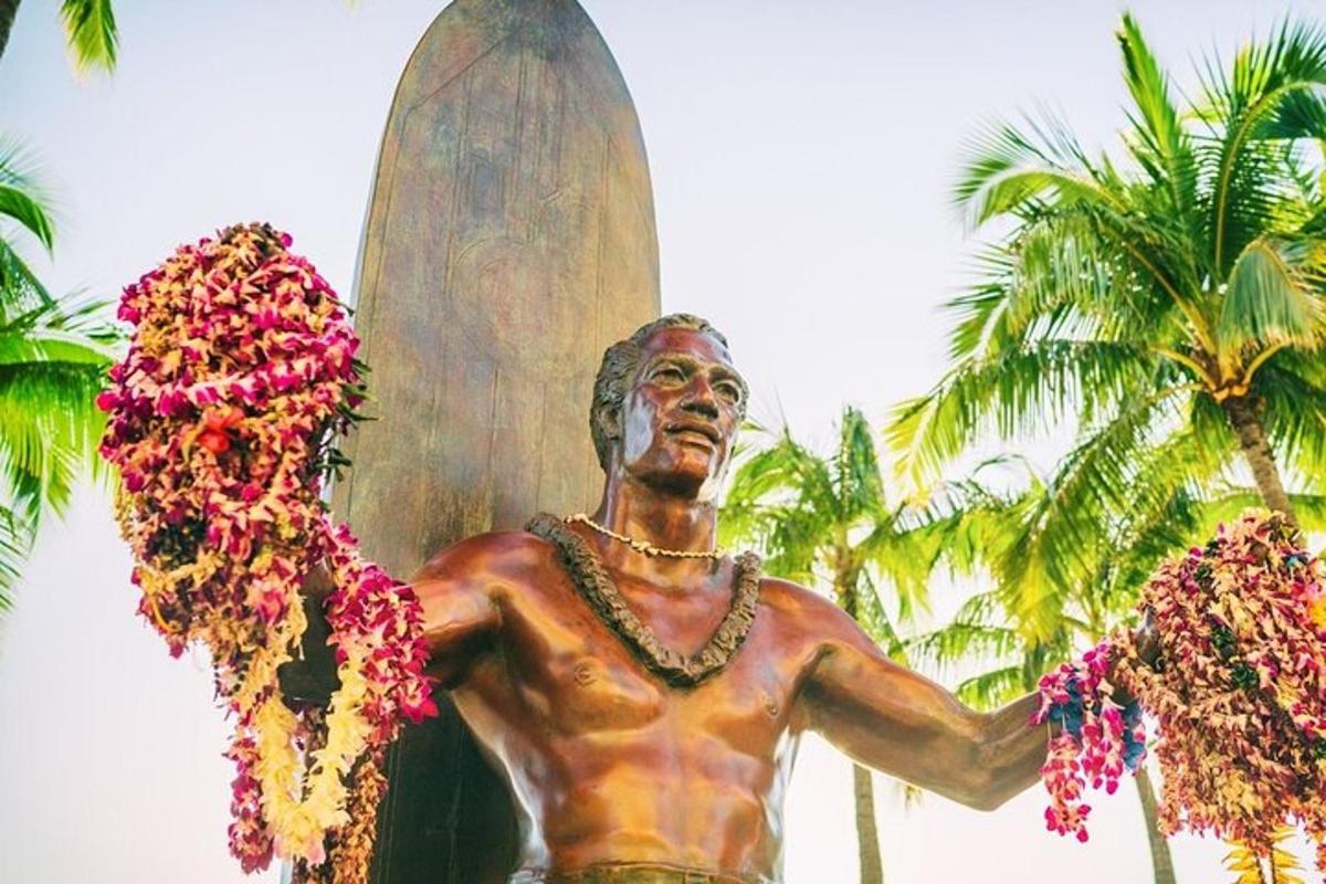 una statua di un uomo che tiene in mano una tavola da surf