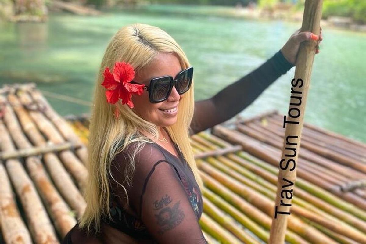 seorang wanita berkaca mata hitam memegang sebatang kayu dengan tanda