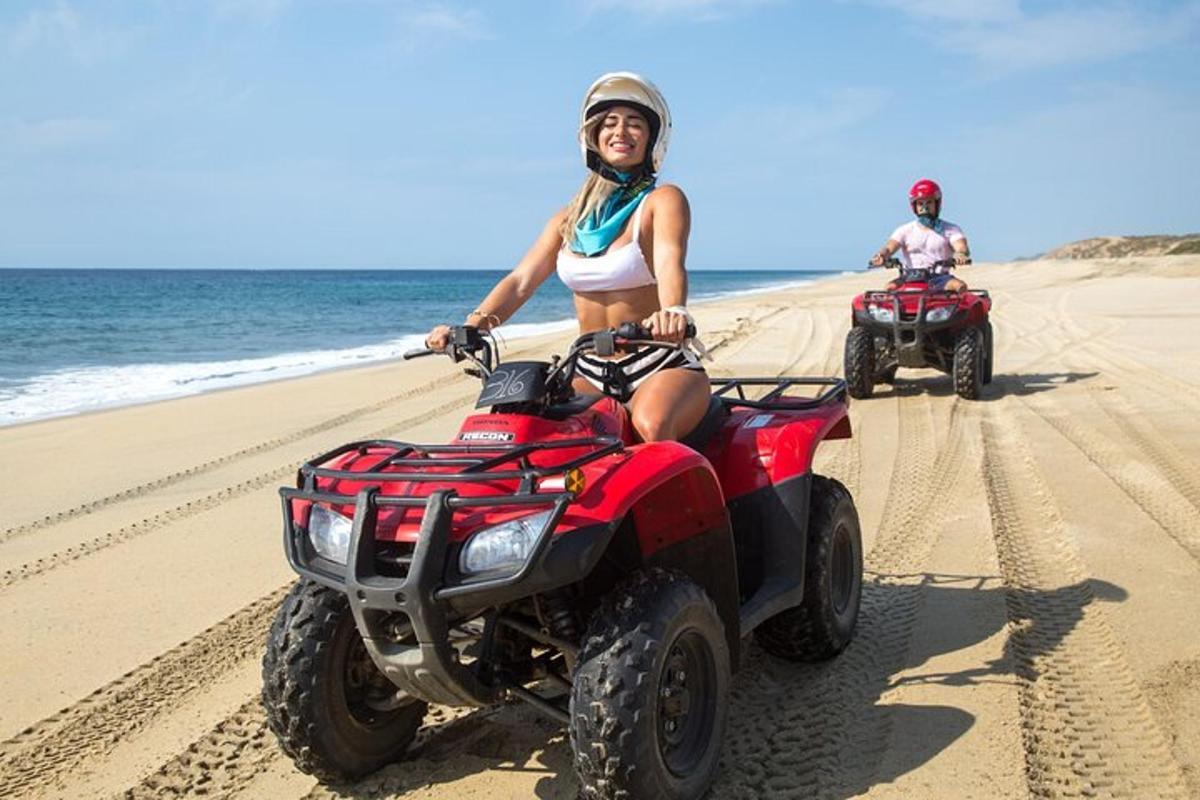 due persone stanno guidando dei quad sulla spiaggia