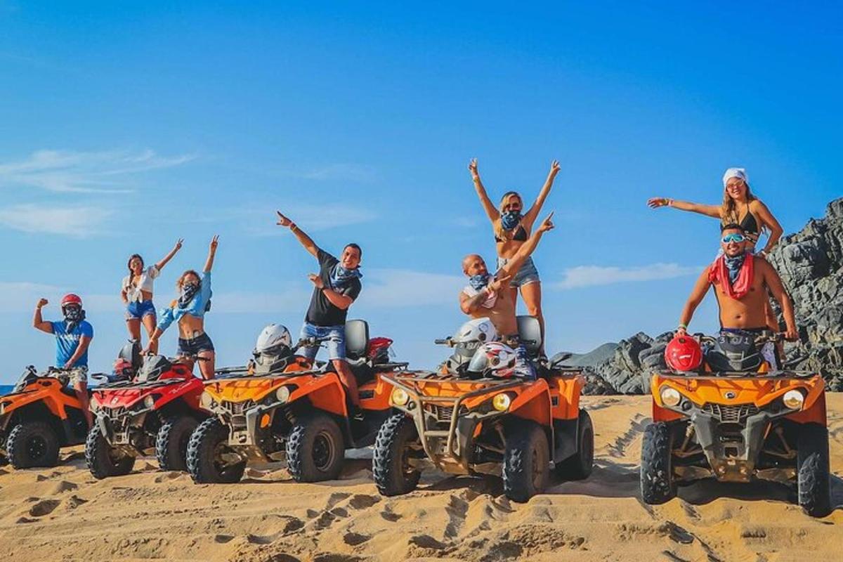 un gruppo di persone in piedi su quad nella sabbia