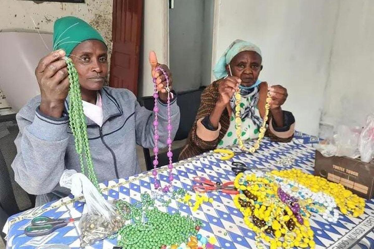 due donne sono sedute a un tavolo con delle perline