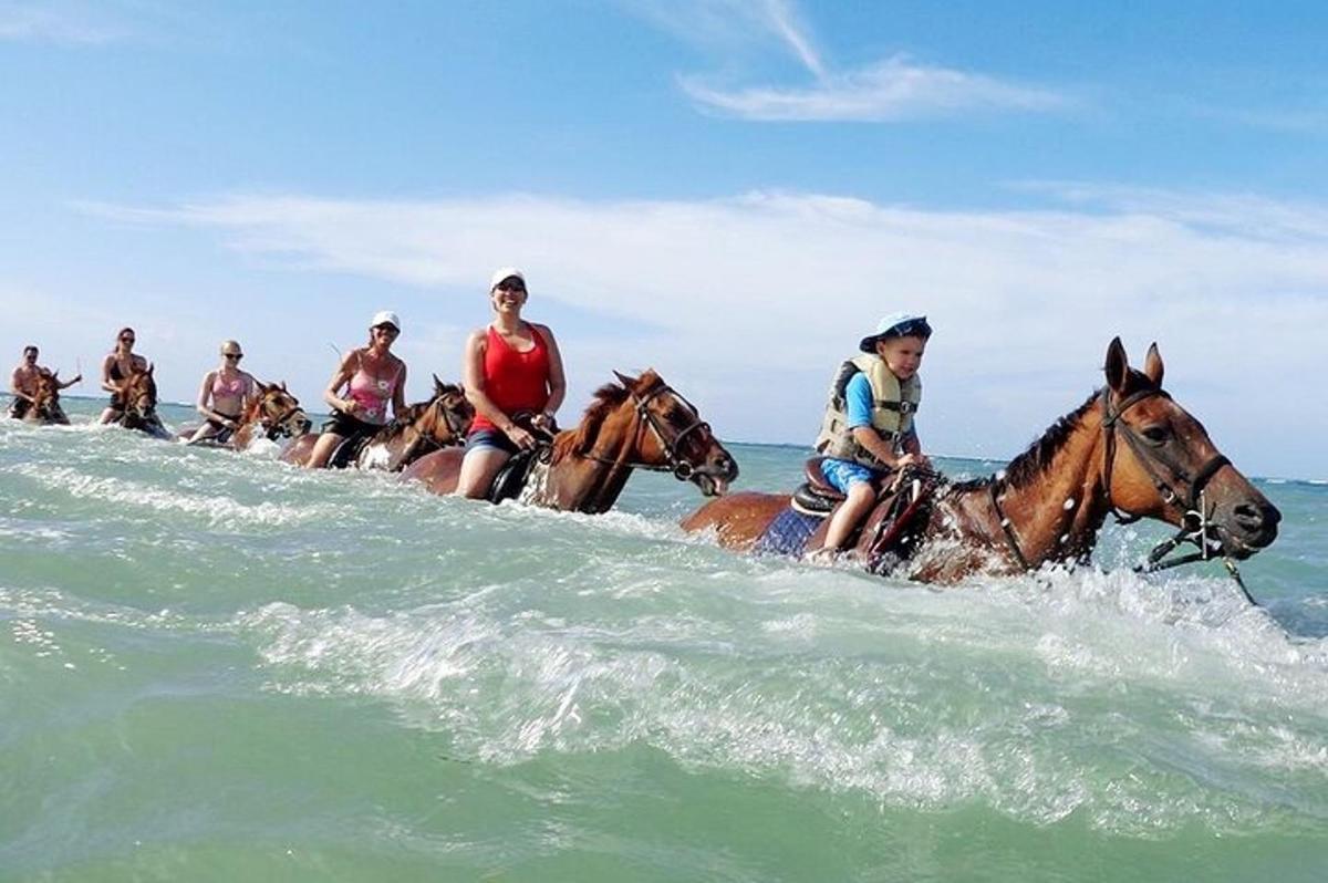 un grup de oameni călare pe cai în ocean