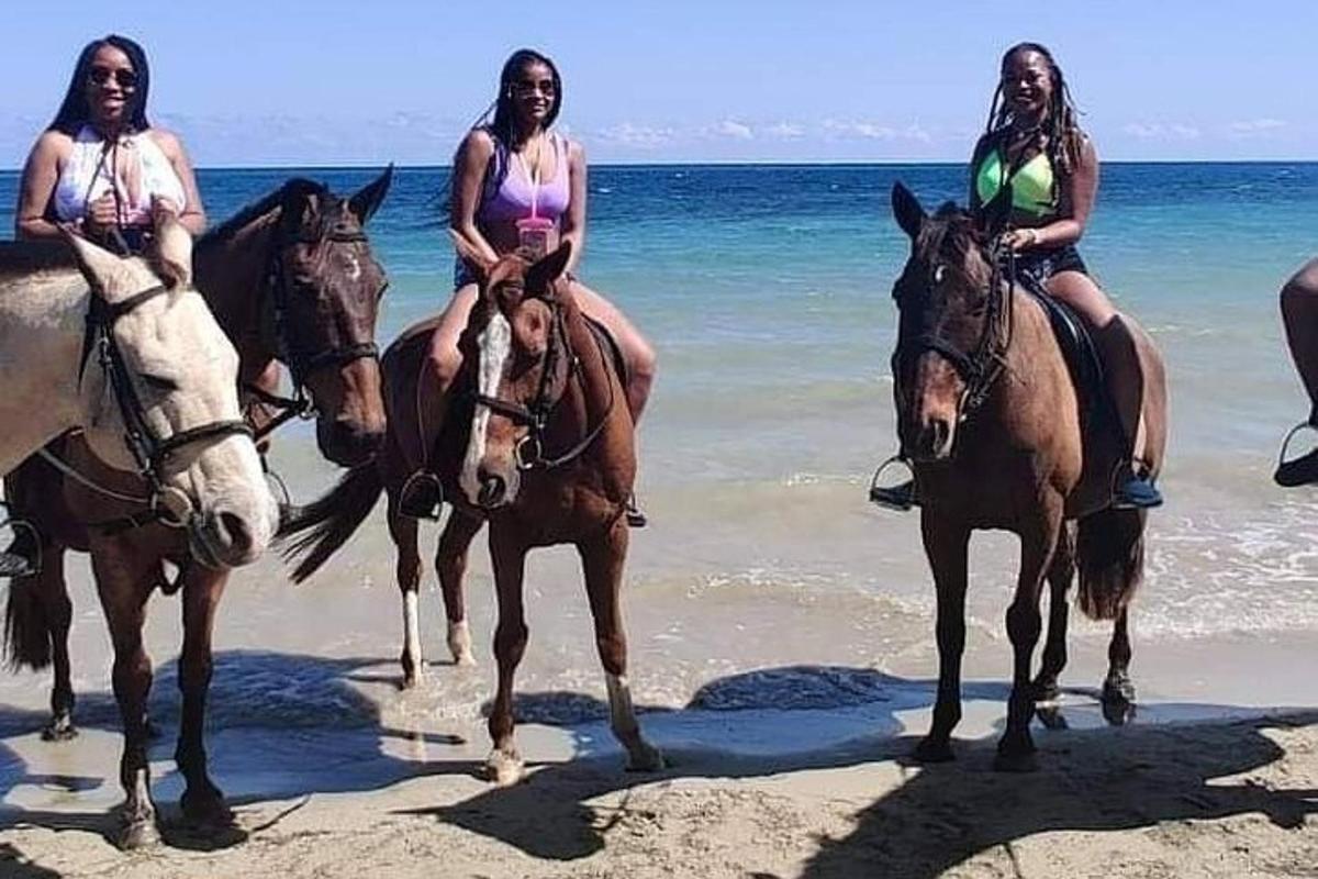 tre donne stanno cavalcando sulla spiaggia